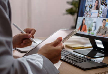 asisn woman video conference busienss meeting with colleage online with tablet at homeの写真素材