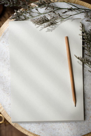Mockup notepad with pencil on round tableの写真素材