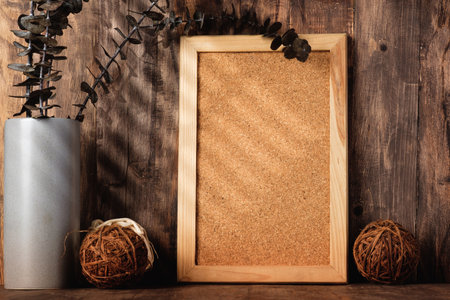 blank corkboard with kitchenware on wood table with sunlightの写真素材