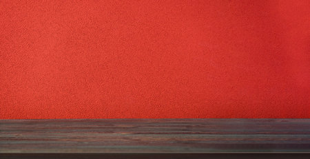 Empty wood table with cement red vivid wall background.Mockup product display for advertiseの写真素材