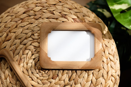 mockup wood photo frame on wicker stood with monstera with sunlightの写真素材