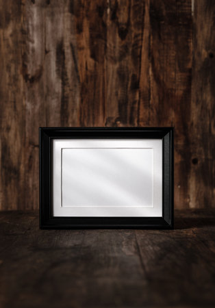 blank black photo frame on wood table and wall witn sunlight from windowの写真素材