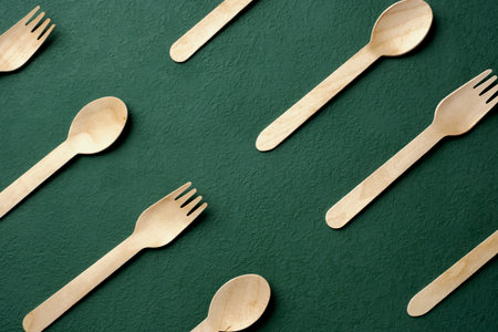 Plastic free set bamboo spoon and fork on dark green background.Zero waste disposable kitchen wareの写真素材