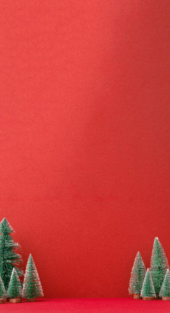 Christmas pine tree group on red vertical background.mockup banner for display content designの写真素材