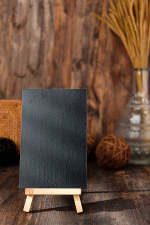 mockup blackbaord on wood table and decor with wicker countryside items.の写真素材