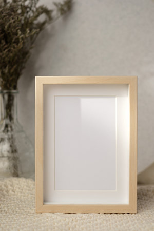 mockup photo frame with flower in vase on white soft wicker tableclothの写真素材