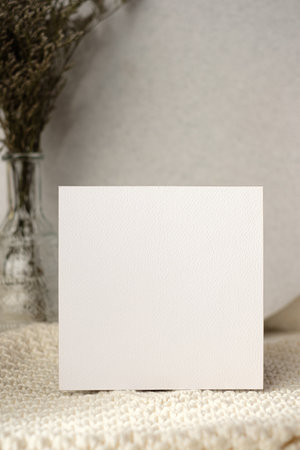 mockup blank wedding  invitation card with flower in vase on white soft wicker tableclothの写真素材