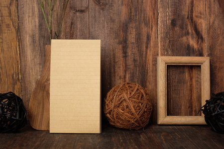 mockup blank line yellow note pad with wood photo frame and wicker ball on tableの写真素材