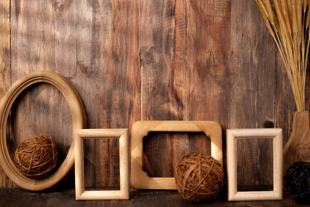 mockup group of wood photo frames on wood table and decor with wicker decoration itemsの写真素材