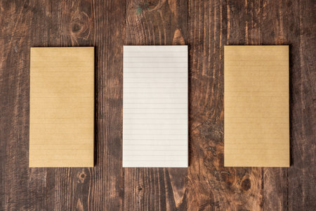 top view of group of yellow notepad align on wood tableの写真素材