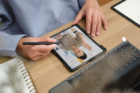 asian woman use mobile while video conference meeting online with tablet at home