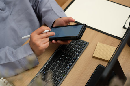 asian woman use mobile while video conference meeting online with tablet at homeの写真素材