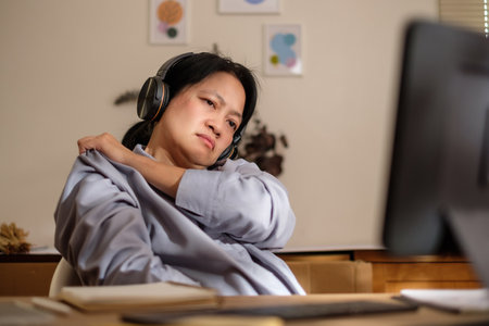 asian woman shoulder ache office syndrome when working long time at homeの写真素材