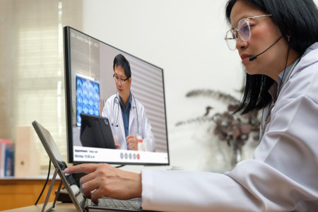 Asian woman doctor video conference discussion with doctor team about diagnosis patient symptomの写真素材