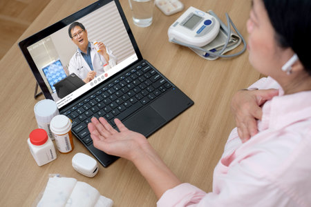 asian woman telemedicine doctor online visit with computer at homeの写真素材
