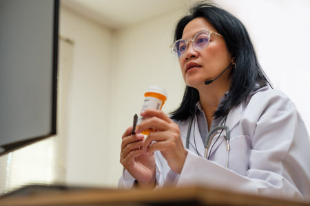 asian woman doctor visit patient video call online diagnose symptom at clinicの写真素材