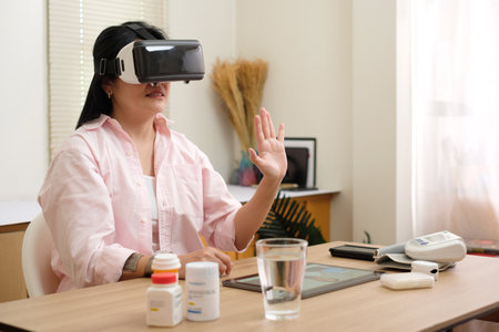 asian woman telemedicine doctor online visit with virtual reality technology vr glasses at homeの写真素材