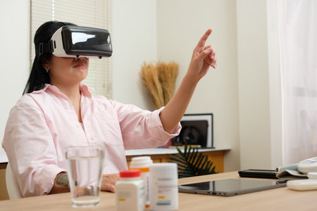 asian woman telemedicine doctor online visit with virtual reality technology vr glasses at homeの写真素材