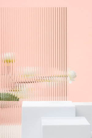 White block pedestal product display peach background with modern Transparency strip glass  and flower with sunshine lightの写真素材
