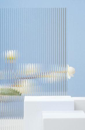 White block pedestal product display blue background with modern Transparency strip glass  and flower with sunshine lightの写真素材