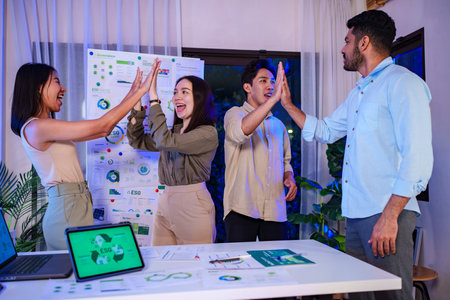 diversity team celebration and high five of sustainability goals is success at green environment office at nightの写真素材
