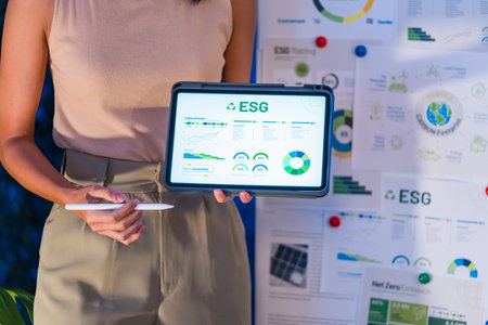diversity team presentation about ESG (environment,socail,governance)  sustainability business goals sdgs in green office at nightの写真素材