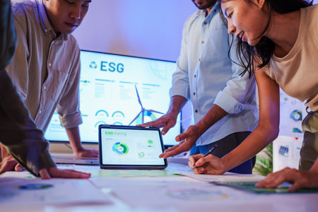 diversity team brainstorming focused on ESG (environment,social,governance)  and renewable energy to reduce pollutions in a sustainable green office at nightの写真素材