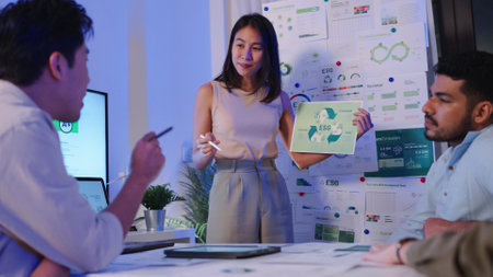 diversity team presentation about ESG (environment,socail,governance)  sustainability business goals sdgs in green office at nightの写真素材