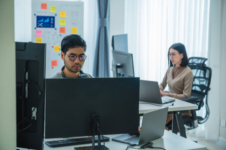 asian woman  and Indian man Developer team working  about programming software data online at officeの写真素材