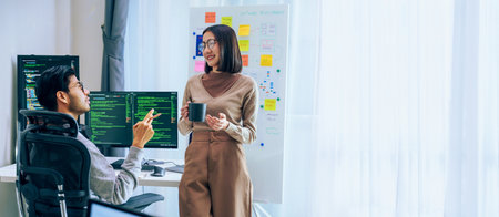 Two software developers engage in a discussion at coffee break time in a modern office, relax emotionの写真素材