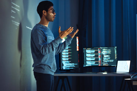 Indian man programmer standing in front of a screen with code projected  presentation the integration of technology and human expertise in software developmentの写真素材