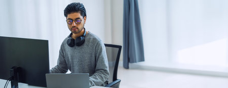 Asian man  prompt engineer develop coding app with software data sitting in front of computer monitor at officeの写真素材