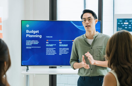 asian leader presenting a financial data and strategies in a modern office with charts and graphs...