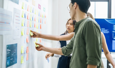 brainstorming session, using sticky notes on a task board (kanban) to organize ideas and workflow in...