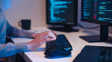 close up hand of Asian prompt engineer develop coding app with software data sitting in front of...