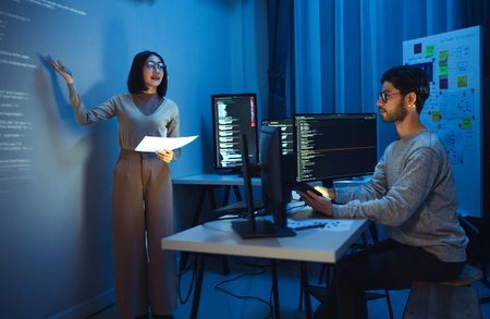 asian woman developers collaborating on a coding project, with one member presentation at code...