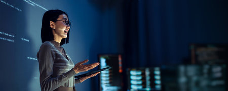 asian woman programmer standing in front of a screen with code projected  presentation the integration of technology and human expertise in software developmentの写真素材