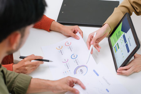 asian financial advisor presenting charts and data on a tablet during couple client...