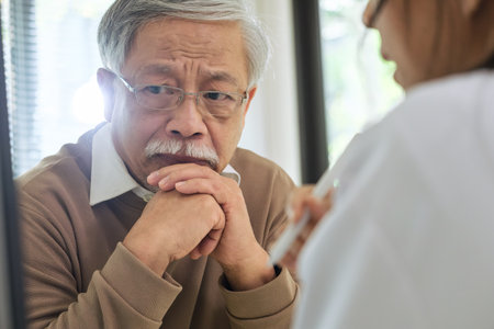 Doctor delivering bad news diagnosis with emotional support to senior patient in hospital care settingの写真素材