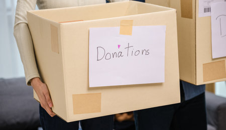 group of friend  holding packing clothes into a donation box.community support, and charitable givingの写真素材