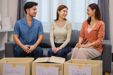 group of friend  holding packing clothes into a donation box.community support, and charitable...