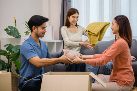 group of friend  sorting and packing clothes into a donation box.community support, and charitable givingの写真素材