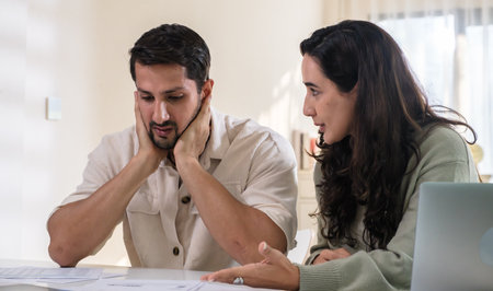 Couple overwhelmed by overdue bills and low income, facing economic stress and inflation-related financial crisisの写真素材