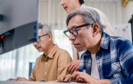 Asian Instructor Teaching Senior in Software Programming and Training Collaborationの写真素材