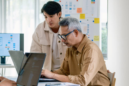 Group of asian senior in a collaborative software development analyzing  flowcharts  during a bootcamp trainingの写真素材