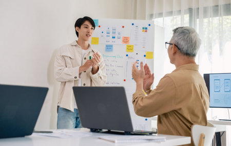 senior programmer bootcamlp,Asian young instructor guides senior learners through a programming on...