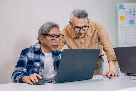 Senior male participating in a computer programming bootcamp, improving skills and learning coding and develope collaborating in brainstorming and coding projectの写真素材