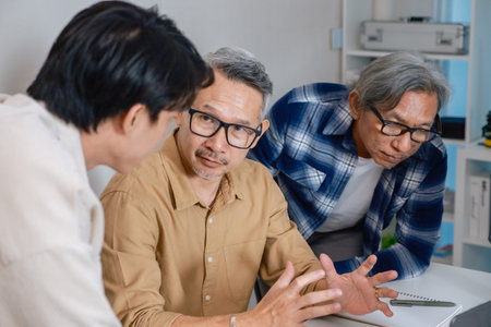 Team of developers collaborating in brainstorming and coding project at office workspaceの写真素材