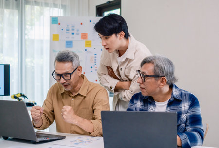 Senior developer team celebrates success in software collaboration and coding at a modern computer...