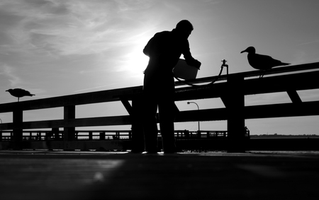 Black And White Photo Of Man On Fishing Pierの写真素材